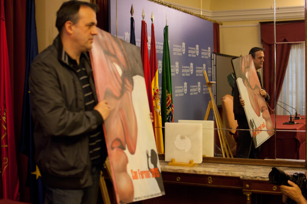 Se puede puede ver a Javier Erice con el cartel en la mano y su reflejo en el espejo de la sala de prensa del ayuntamiento de Pamplona