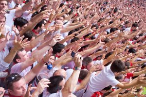 Un montón de gente con las manos levantadas en el Chupinazo de Pamplona en Sanfermin. Tradición de levantar las manos con la salida de la banda de chistularis hasta que se arrancan a tocar.