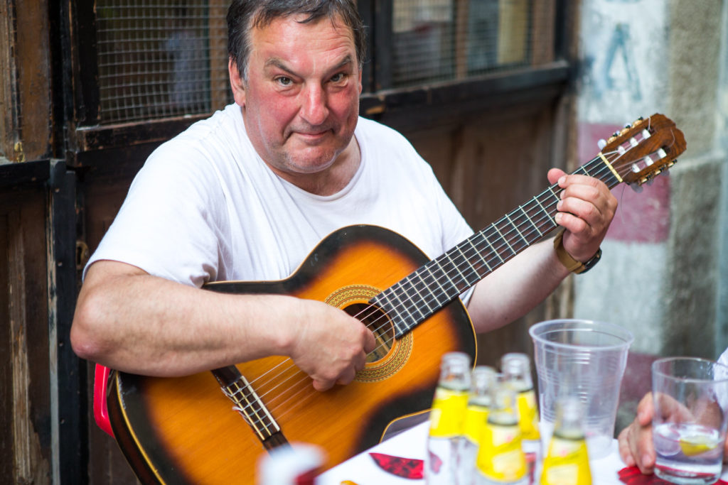 Señor tocando la guitarra de risas en Sanfermin