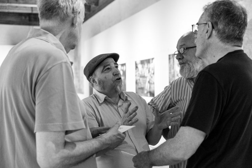 Se ve a Luis Azanza charlando animadamente con tres fotógrafos más entre los que se identifica a Javier Sesma de Diario de Navarra. Es una charla en la inauguración de la exposición Universo Sf de julio de 2019.